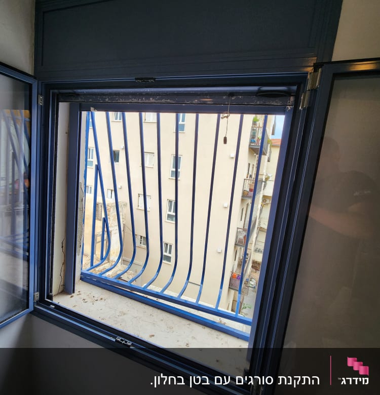 חלון עם מסגרת מתכת כחולה וסורגים